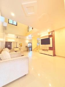 a large living room with a couch and a tv at Serenity Villa in Rushikonda