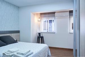 a bedroom with a bed with towels on it at The Clock Tower Apartment in Jaén