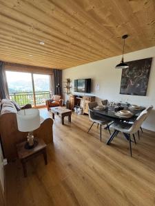 a living room with a wooden ceiling and a table at Chalet Les Combes in Notre-Dame-de-Bellecombe