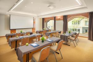 a conference room with tables and chairs and a whiteboard at Hotel Dubrovnik in Zagreb