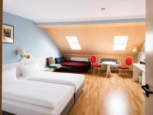 a room with two beds and a couch and a table at Hotel Elisenhof in Chemnitz