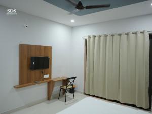 a room with a desk and a television and a curtain at Hotel Chandra Hari Palace in Sānchor