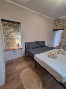 a bedroom with a bed and a stone wall at Bella vista 2 in Castellino Tanaro
