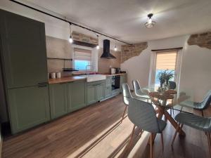 a kitchen with green cabinets and a table and chairs at Bella vista 2 in Castellino Tanaro