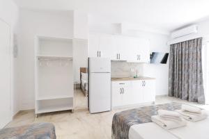 a white kitchen with a refrigerator and a table at Vila Ori in Ksamil +41 photos