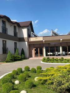 a building with a lot of bushes in front of it at Pensiunea Eden in Jibou