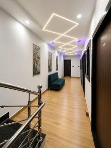 a hallway in an office with a couch and a television at Hotel 5G in Bhopal