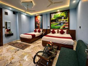 a hotel room with two beds and a couch at Hotel 5G in Bhopal