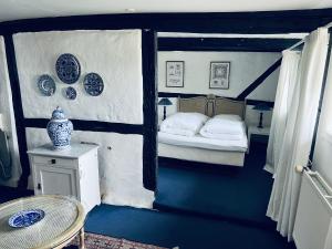 a blue and white bedroom with a bed and a table at Lodsoldermandsgården in Rørvig +61 photos
