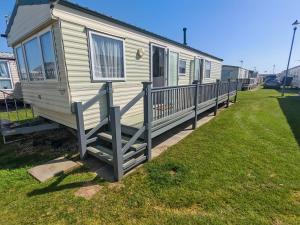 a mobile home with a porch and a fence at 237 Sealands, 6 Birth caravan in Ingoldmells