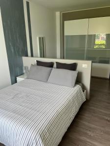 a bedroom with a large bed with striped sheets at Casa Luisa in Bellano