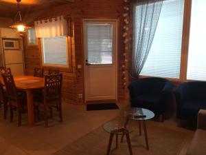 a living room with a table and chairs and a door at Tenutahko in Tahkovuori