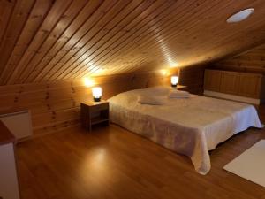 a bedroom with a large bed in a wooden room at Tenutahko in Tahkovuori