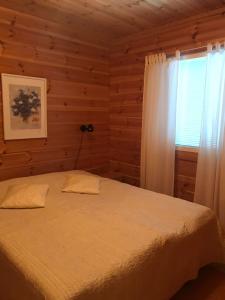 a bedroom with a bed and a window at Tenutahko in Tahkovuori +2 photos