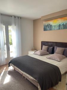a bedroom with a large bed with a painting on the wall at La Villa D’Aimée in Vidauban +22 photos