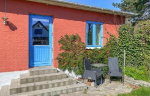 a house with a blue door and a table and chairs at 2 Bedroom Nice Home In Hundested in Hundested +8 photos
