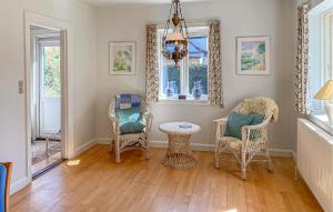 a living room with chairs and a table and a chandelier at 2 Bedroom Nice Home In Hundested in Hundested