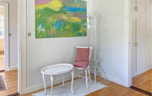 a table and a chair in a room with a painting at 2 Bedroom Nice Home In Hundested in Hundested