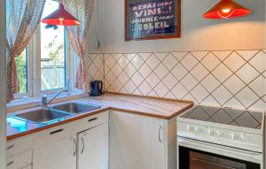 a kitchen with white cabinets and a sink and a window at 2 Bedroom Nice Home In Hundested in Hundested
