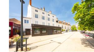 a large white building on a city street at Pop Hôtel in Dijon
