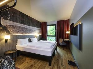 a bedroom with a large white bed in a room at Ibis Styles Singen 24h geöffnet in Singen