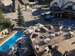 an overhead view of a pool with tables and chairs at Grand Hôtel & Spa NUXE Serre Chevalier in Saint-Chaffrey