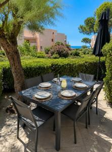 a blue table with chairs and an umbrella at Le Cosy - T4 avec terrasse privée, Face à la mer avec parking et wifi in Sète