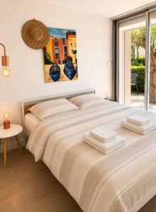 a large bed in a white room with a window at Le Cosy - T4 avec terrasse privée, Face à la mer avec parking et wifi in Sète