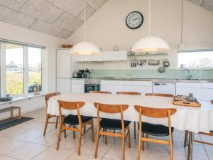 a kitchen with a table and chairs and a clock at 4 star holiday home in Børkop in Børkop