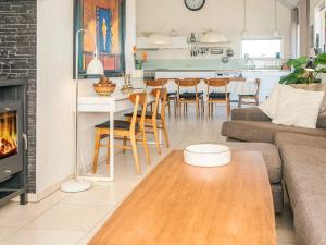 a living room with a couch and a table with a fireplace at 4 star holiday home in Børkop in Børkop