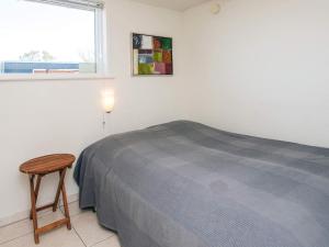 a bedroom with a bed and a stool next to a window at 4 star holiday home in Børkop in Børkop +21 photos
