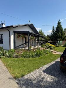 a house with a porch with flowers on it at Kwiatowy Zakątek na Zaciszu in Radocza