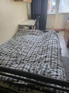 ein Bett mit einer Decke darauf in einem Zimmer in der Unterkunft Reading Studio Flat in Caversham