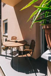 a wooden table and two chairs on a patio at Malomfészek Apartman in Tapolca