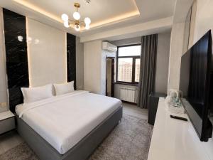 a bedroom with a large bed and a television at Firdavsi Hotel in Dushanbe +82 photos