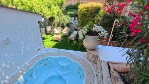 a garden with a jacuzzi tub in a yard at Villa al Duomo Taormina - Suite & Rooms in Taormina