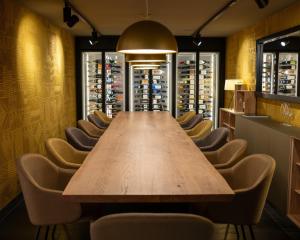 a long table and chairs in a wine cellar at HUUS Gstaad in Gstaad