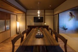 a dining room with a table and a tv at Hikoso-machi Gin no Ma in Kanazawa