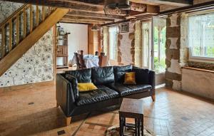 a living room with a black leather couch at 2 Bedroom Gorgeous Home In Noyal-Sous-Bazouges in Noyal-sous-Bazouges