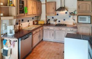 a kitchen with wooden cabinets and a sink at 2 Bedroom Gorgeous Home In Noyal-Sous-Bazouges in Noyal-sous-Bazouges