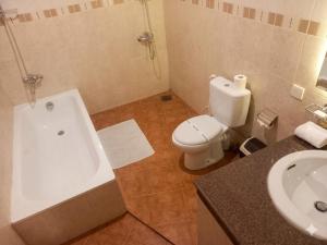 a bathroom with a tub and a toilet and a sink at Hotel Lakefield in Kandy +15 photos