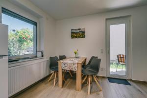 a dining room with a table and chairs and a window at Malomfészek Apartman in Tapolca +10 photos