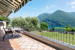 a patio with a table and chairs and a view of a lake at Villa Porlezza Lake view in Cima