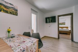 a dining room with a table and chairs and a bedroom at Malomfészek Apartman in Tapolca