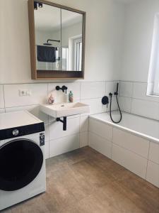 a bathroom with a sink and a washing machine at Penthouse mit Seeblick & Terrasse Top 7 in Reifnitz +51 photos