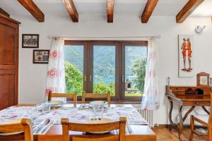 a dining room with a table and a piano at Villa Porlezza Lake view in Cima