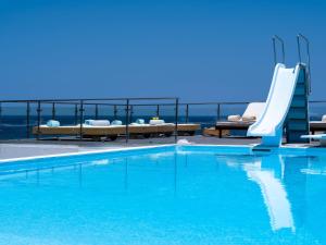 a pool with a slide and a swimming pool at Icarus Luxury Beachfront Villa in Gialiskari