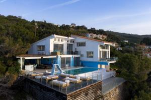 a villa with a swimming pool and a house at Icarus Luxury Beachfront Villa in Gialiskari