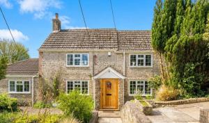a brick house with a wooden door at Old Weavers in Corsley