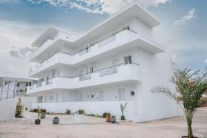 a white building with plants in front of it at ILIADA Boutique Rooms in Faliraki